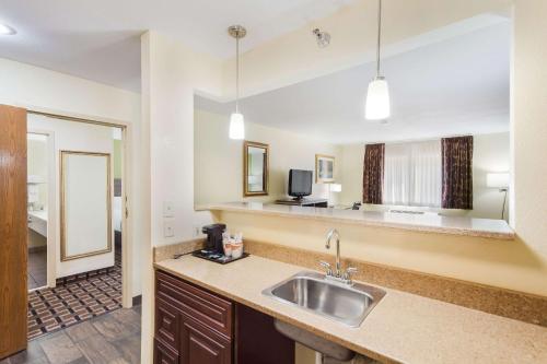 a kitchen with a sink and a living room at Quality Inn Lincoln Cornhusker in Lincoln