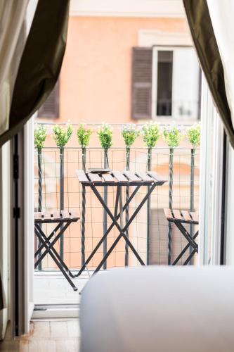 a balcony with a table with potted plants on it at Relais Donna Lucrezia in Rome