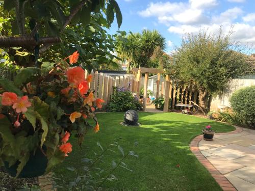 a garden with orange flowers and a fence at Bub Lane Cottage in Christchurch