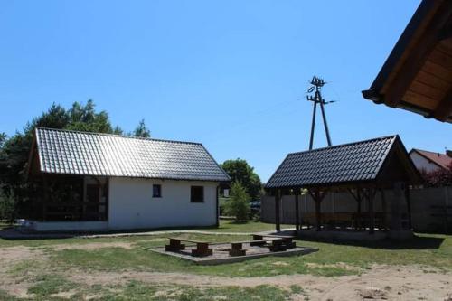 a building with a picnic table and a gazebo at Domek letniskowy 6-osobowy całoroczny nad jeziorem Wilczyńskim in Świętne