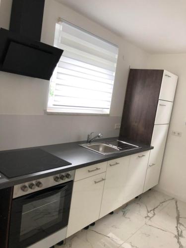 a kitchen with white cabinets and a sink and a window at Luxusvilla Neubau 2 in Oberasbach