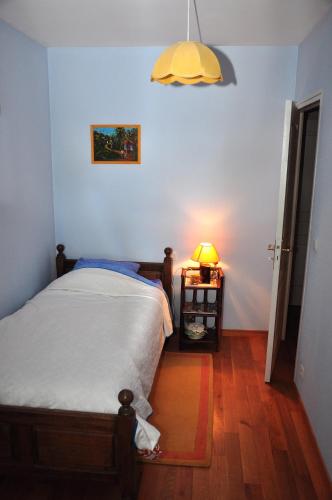 a bedroom with a bed and a lamp on a table at La Grande Malardiere in Saint-Georges-Buttavent
