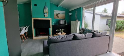 een woonkamer met een bank en een open haard bij Surfin in Koksijde