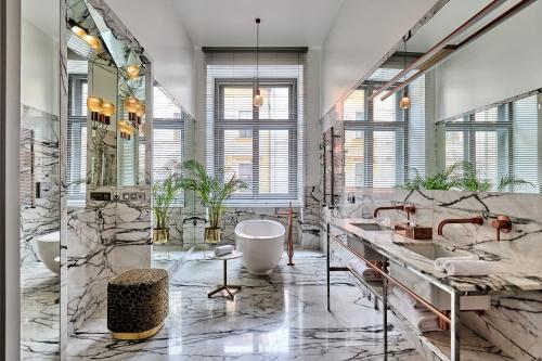 a large bathroom with two sinks and a tub at Hotel H15 Luxury Palace in Kraków