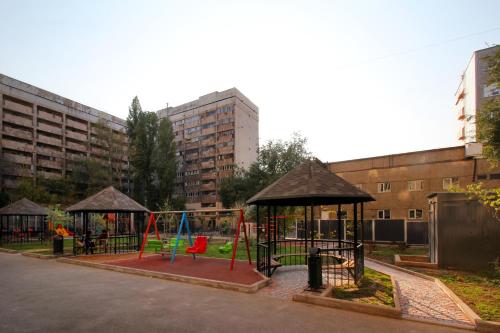a playground with swings and play equipment in a city at Cozy studio in the best area! 3 in Almaty