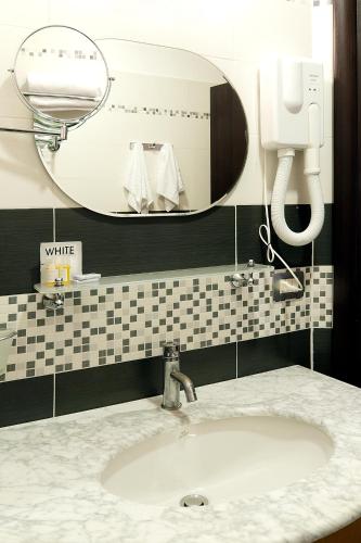 a bathroom with a white sink and a mirror at Roman Residence in Rome