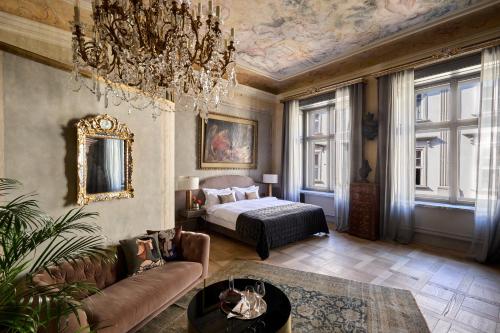 a living room with a bed and a chandelier at Hotel H15 Luxury Palace in Kraków