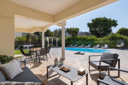 a patio with chairs and a table and a pool at Villa Montefile in Triánta