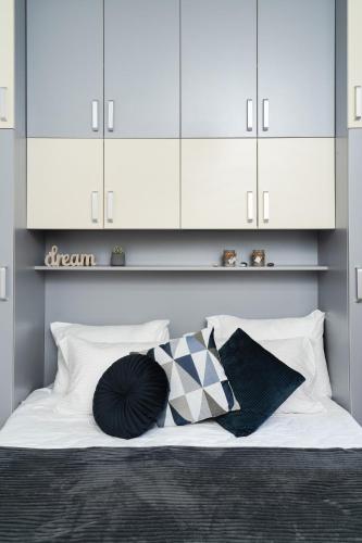 a bed with white cabinets and black and white pillows at Villa Adelaida in Sarajevo
