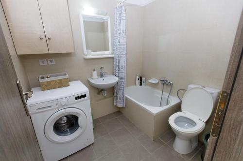 een badkamer met een toilet, een wastafel en een wasmachine bij Aristotle's Studio in Kalamata