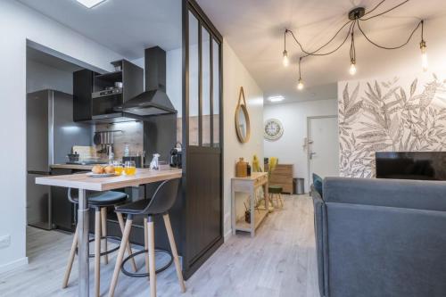 a kitchen and living room with a table and chairs at La feuillette - vieille ville - parking gratuit in Annecy