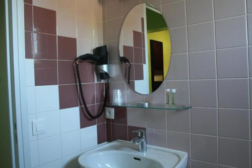 y baño con lavabo y espejo. en La Bonne Etape, en Amboise