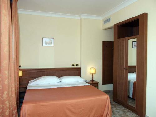 a hotel room with a bed and a mirror at Hotel Villa Bianca Resort in Taormina