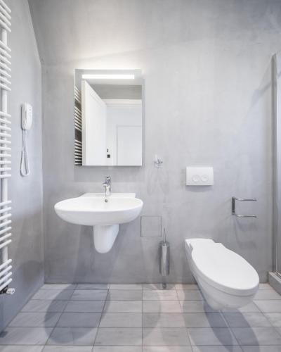 a white bathroom with a sink and a toilet at Casa Popeea Boutique Hotel in Brăila