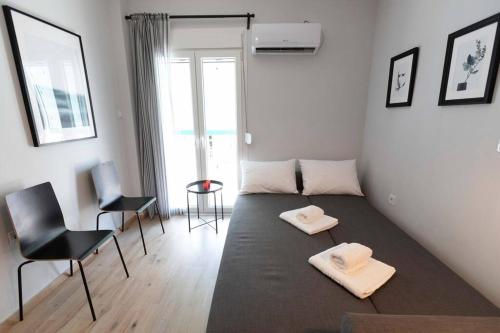 um quarto com uma cama com duas toalhas brancas em The brand new House meets the ideal location Apt2 em Atenas