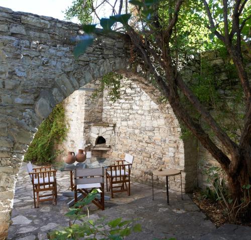 a stone wall with a table and chairs and an oven at Ample Places in Pano Lefkara
