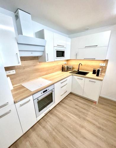a kitchen with white cabinets and a sink at Angel Apartment Černý důl in Cerny Dul