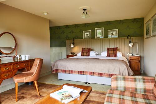 1 dormitorio con cama, escritorio y silla en The Groes Inn, en Conwy