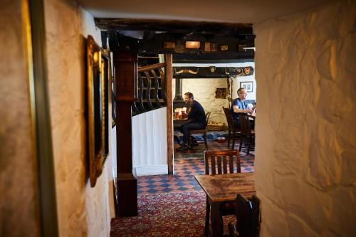 two men sitting at a table in a room at The Groes Inn in Conwy