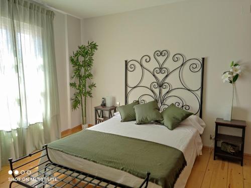 a bedroom with a large bed with green pillows at Rucanon 1 La casa del pueblo 4 Estrellas in Montánchez