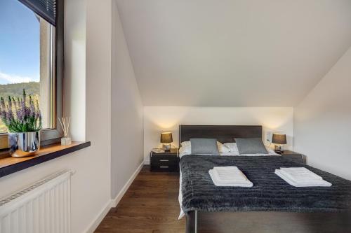 a bedroom with two beds and a window at Apartament 7.0 in Roztoka Wielka