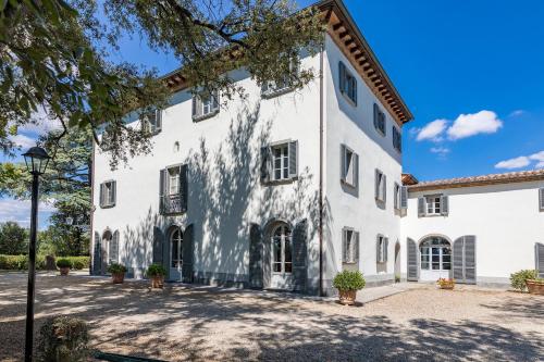 un grand bâtiment blanc avec une cour dans l'établissement Antica Villa Merelli 24, Emma Villas, à Monte San Savino