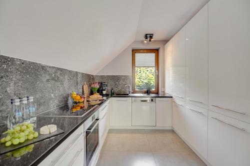 a kitchen with white cabinets and fruits on the counter at Apartament 7.0 in Roztoka Wielka