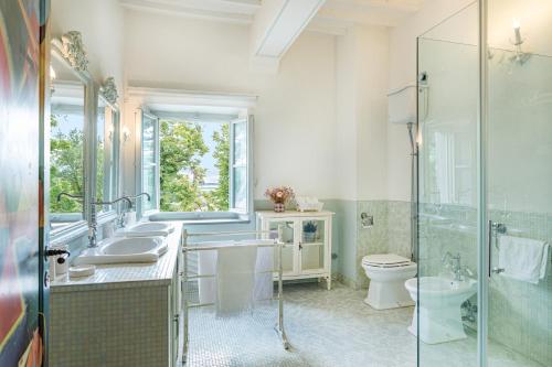 Un baño con dos lavabos y una ducha y un inodoro. en Antica Villa Merelli 24, Emma Villas, en Monte San Savino