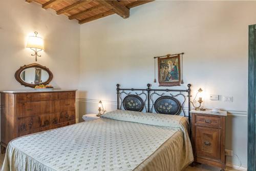 Un dormitorio con una cama grande y un espejo. en Antica Villa Merelli 24, Emma Villas, en Monte San Savino