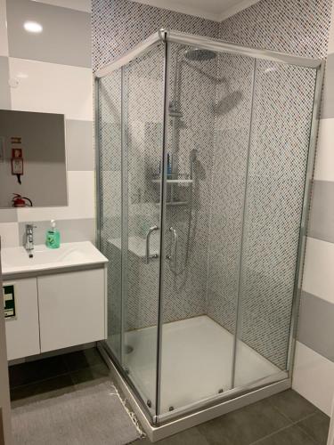 a shower stall in a bathroom with a sink at Liberty Guest House in Ponte de Sor