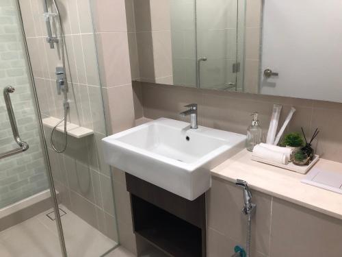 ein Badezimmer mit einem weißen Waschbecken und einer Dusche in der Unterkunft JW Homestay The Ridge KL East in Kuala Lumpur