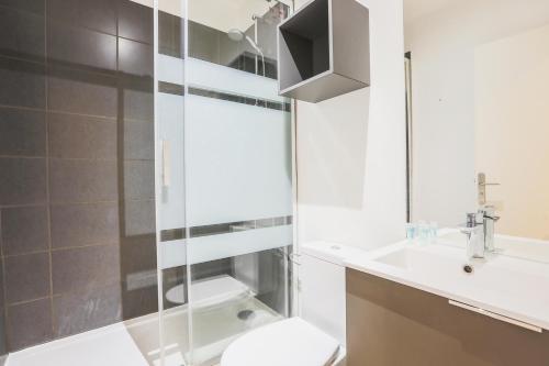 La salle de bains est pourvue d'une douche, de toilettes et d'un lavabo. dans l'établissement "Petit Royal" Confort Thermes, à Royat