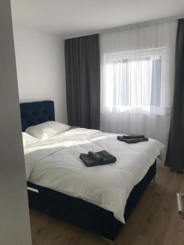 a bedroom with a bed with two black shoes on it at Central Аpartment Foca with garage in Foča