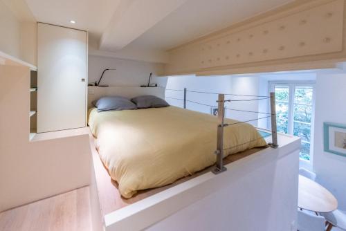 une chambre avec un lit dans une pièce blanche dans l'établissement Happyfew Liberty, à Nice