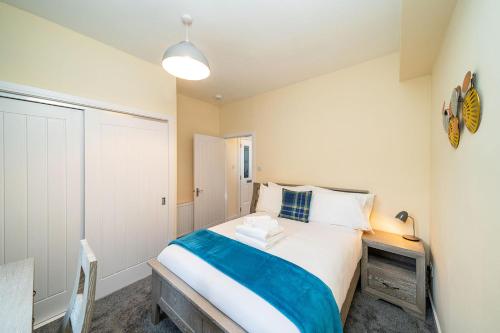 a bedroom with a large bed with a blue blanket at Rosemount Residence in Aberdeen