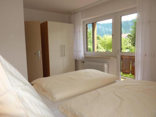 Habitación blanca con cama y ventana en Apartmenthaus Sonnenschein - Chiemgau Karte, en Inzell
