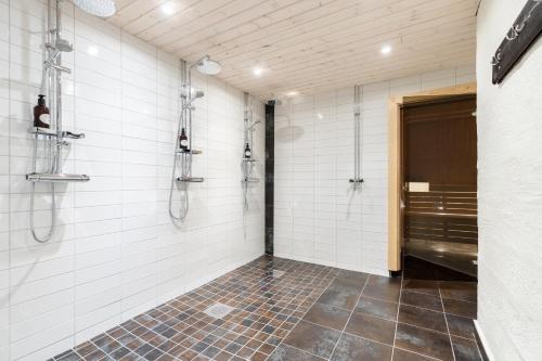 uma casa de banho com paredes em azulejos brancos e um chuveiro em Sporthotellet Idre em Idre