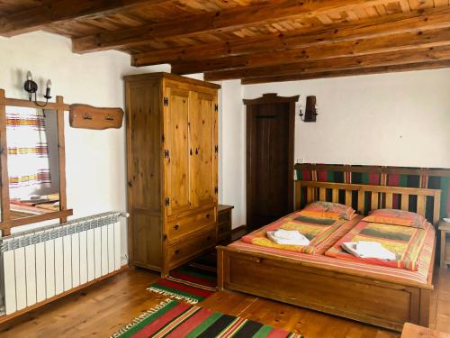 a bedroom with a bed and a wooden cabinet at Baba Stana Houses in Apriltsi