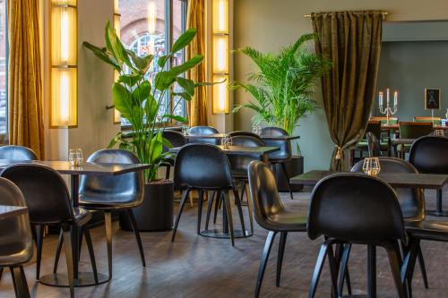 un restaurante con mesas, sillas y plantas en Hotel Astoria, Best Western Signature Collection, en Copenhague