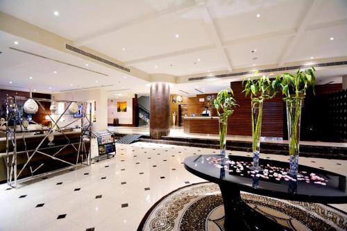 un vestíbulo con una mesa con plantas. en Millennia Olaya Hotel, en Riad