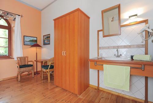 La salle de bains est pourvue d'un lavabo et d'une armoire en bois. dans l'établissement Pension Altes Posthaus, à Dangast