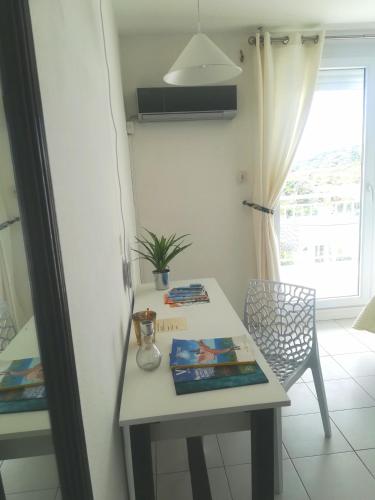 a table and a chair in a room with a window at Happy Residence - Orient Beach 09 in Cul de Sac