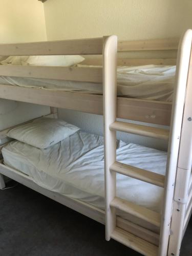 Ce dortoir comprend 2 lits superposés et des draps blancs. dans l'établissement Maison confortable à Saint-Cyprien avec piscine partagée, à Saint-Cyprien