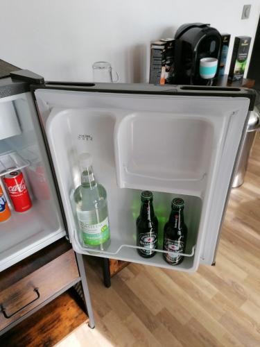 an open refrigerator with bottles of water in it at Stylisches kleines Studio -Zentral gelegen in Leverkusen Wiesdorf - Friedrich Ebert Platz 5a , 4te Etage mit Balkon--Kaution Pflicht-- in Leverkusen