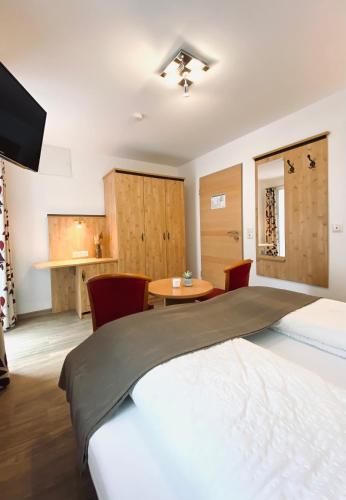 a bedroom with a large bed and a table at Gästehaus Achental in Berchtesgaden