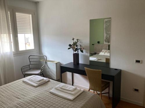 um quarto com uma cama, uma secretária e um espelho em Appartamento Golia em Vicenza
