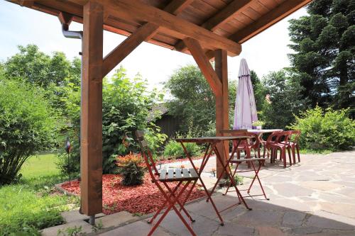 a patio with a table and chairs and an umbrella at Gästehaus Willaringen in Rickenbach