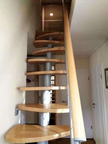 a spiral staircase in a house with wooden treads at fewo-brigitte in Buxtehude