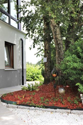 a garden in front of a building with a tree at Gästehaus Willaringen in Rickenbach