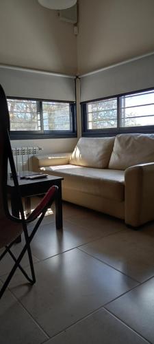 a couch in a room with a table and a chair at Complejo Megevand in Río Ceballos
